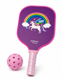 Kids pickleball paddle with a purple unicorn and rainbow design and pink grip next to a pink ball