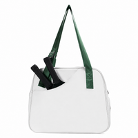 White pickleball tote bag with a green strap and two paddles in the angled front pocket