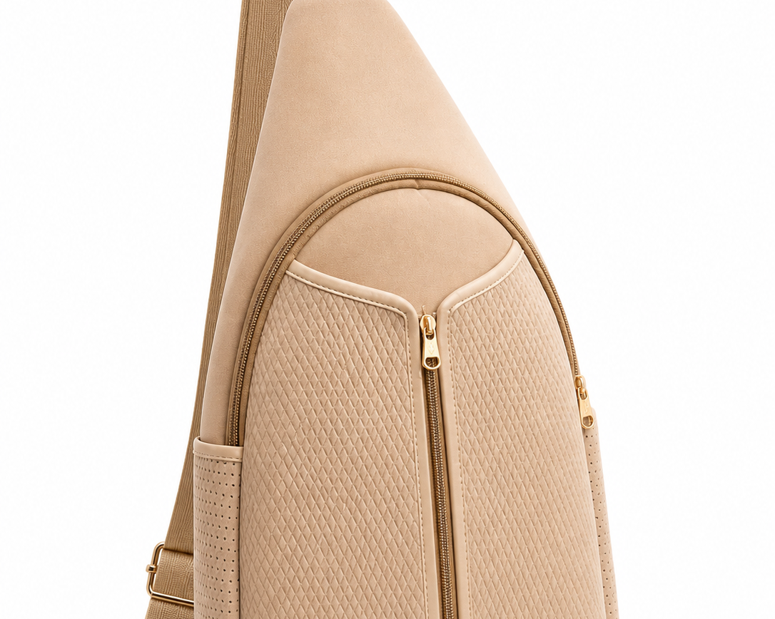 Side view of beige neoprene pickleball sling bag with adjustable strap worn crossbody 