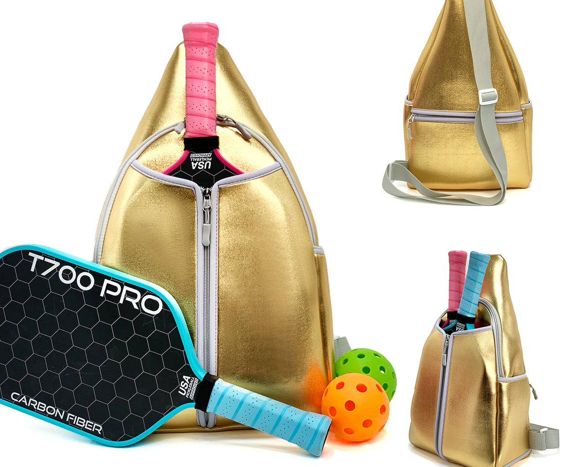 Gold neoprene pickleball sling bag with honeycomb texture and adjustable crossbody strap shown with paddle and pickleball