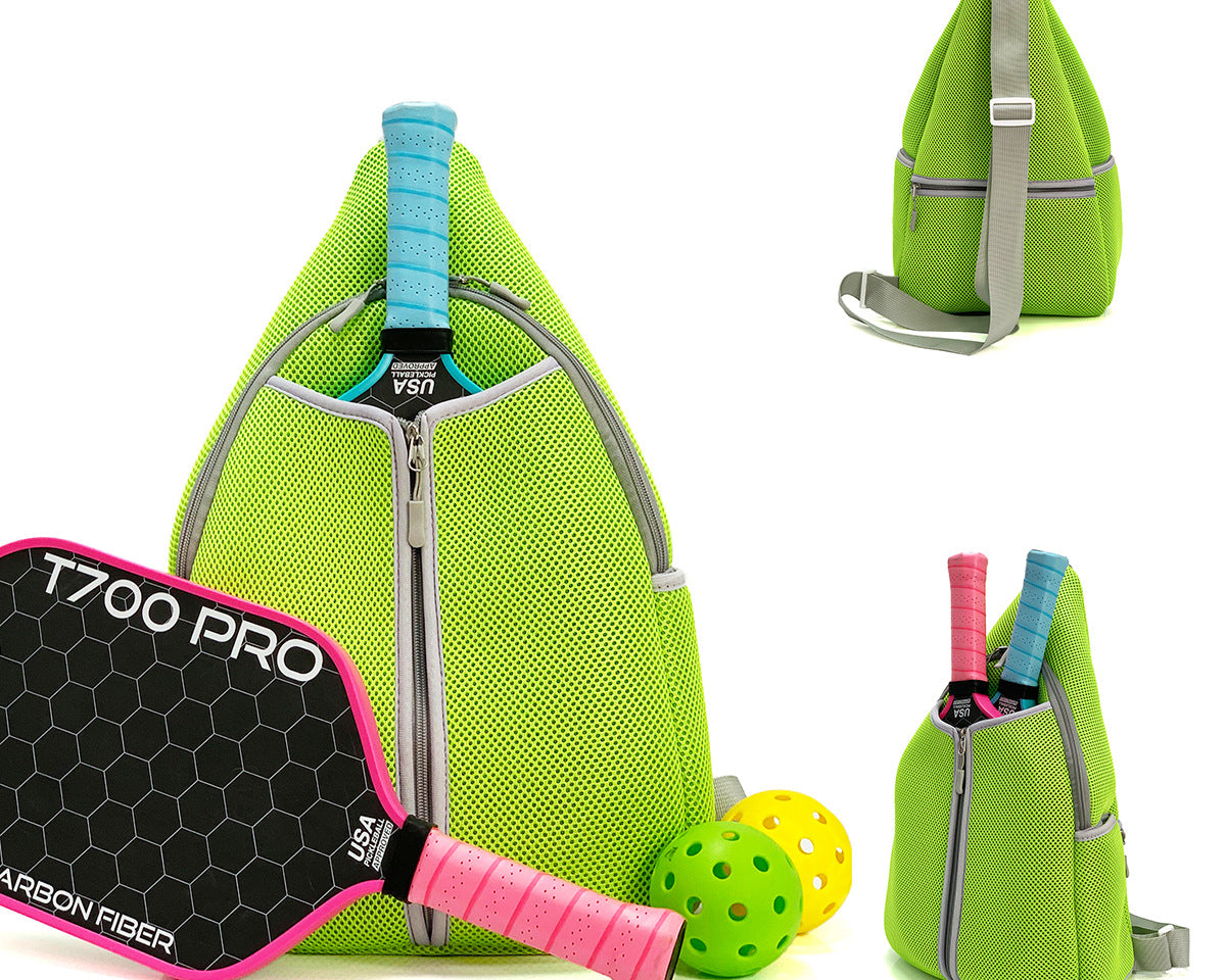 Green neoprene pickleball sling bag with honeycomb texture front panel and adjustable crossbody strap shown with paddle and balls