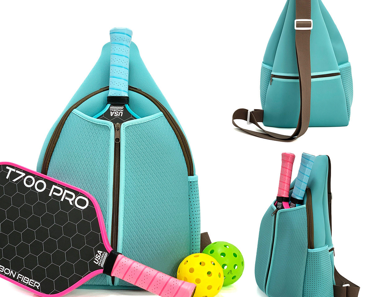 Light blue neoprene pickleball sling bag with honeycomb texture and adjustable crossbody strap shown with paddle and pickleball