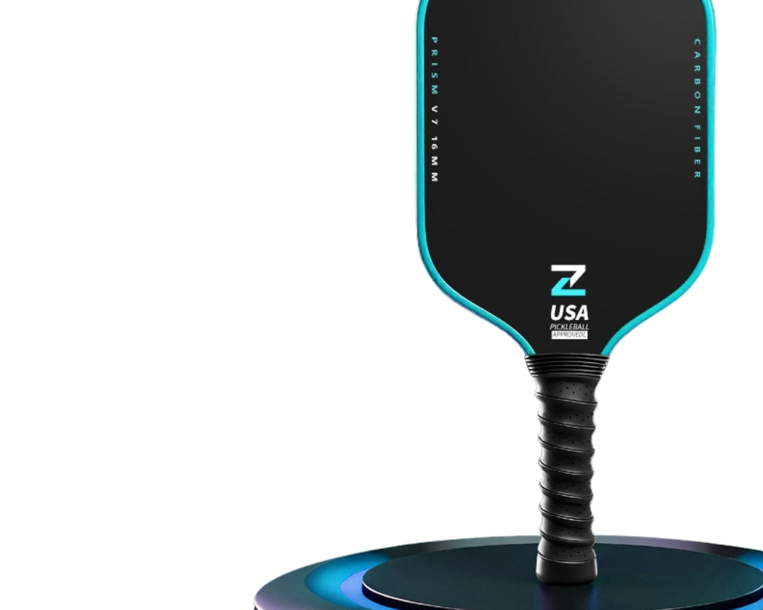 Prism V7 carbon fiber pickleball paddle in blue with T700 matte friction surface, premium TPU edge guard and shock-absorbing black ribbed grip