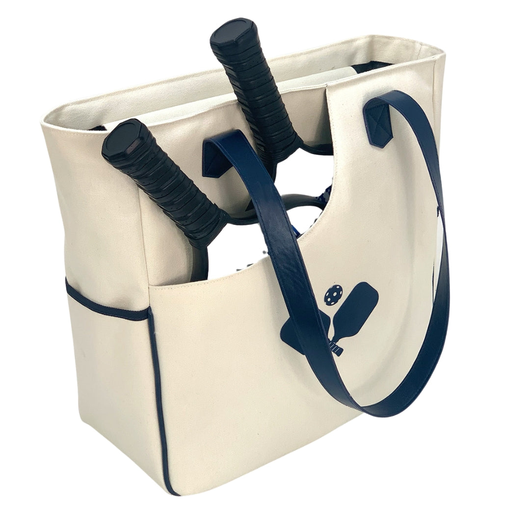  Women carrying a stylish pickleball tote bag in white racket pattern, transitioning seamlessly from the court to everyday life