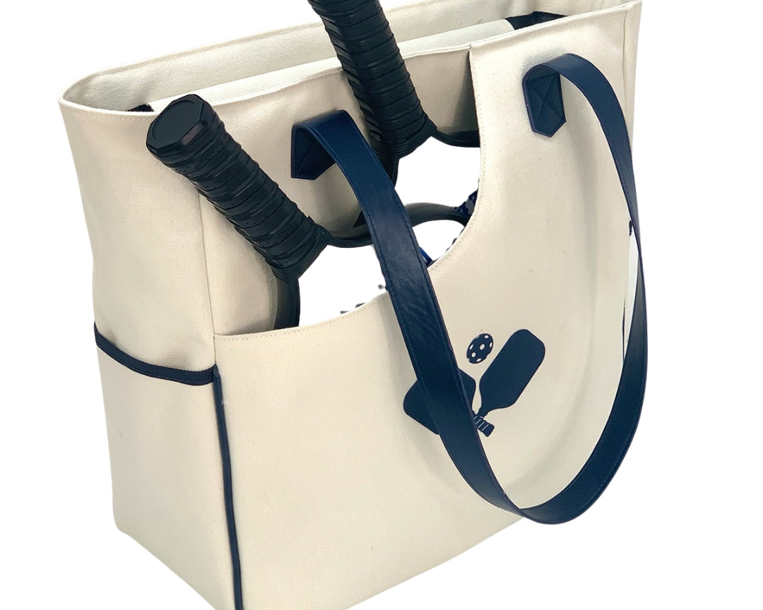  Women carrying a stylish pickleball tote bag in white racket pattern, transitioning seamlessly from the court to everyday life